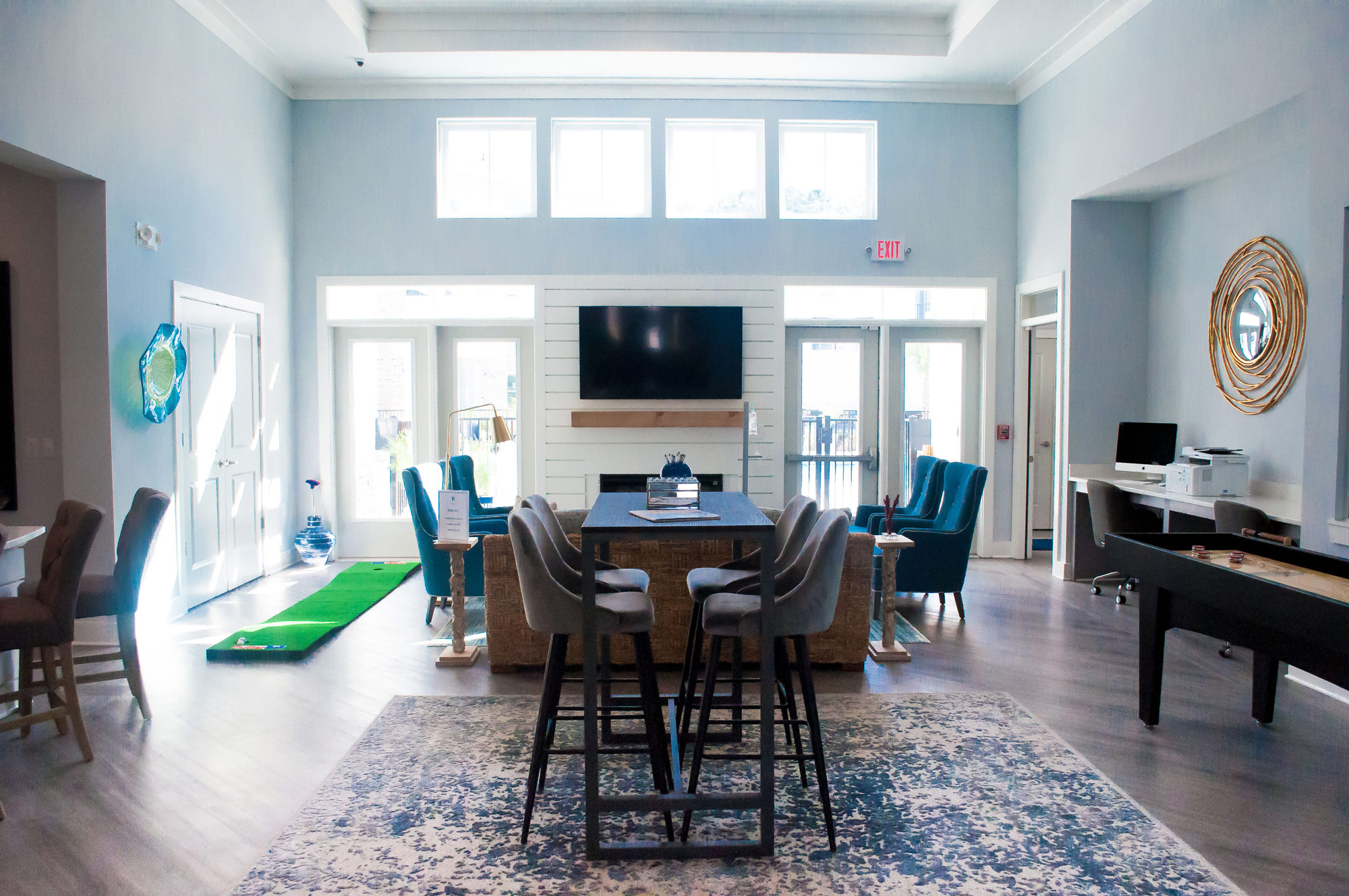 clubhouse with seating, computer, tv, fireplace, shuffleboard, and indoor putting green.