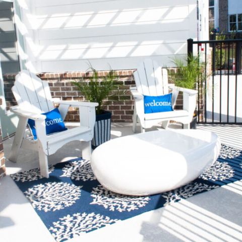 adirondack chairs with welcome pillows in an outdoor seating area