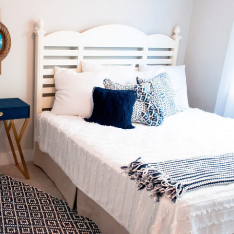 full-size bed in bedroom with white and navy decor