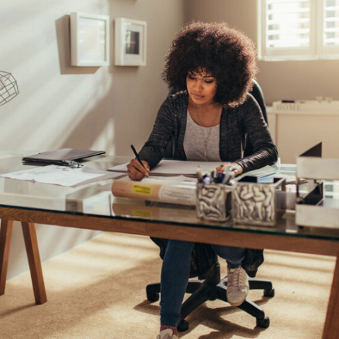 woman writing at a desk in a home office