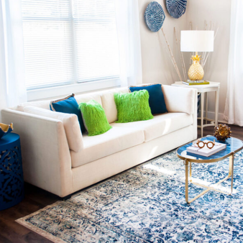 small loveseat in the living room with navy decor and coffee table