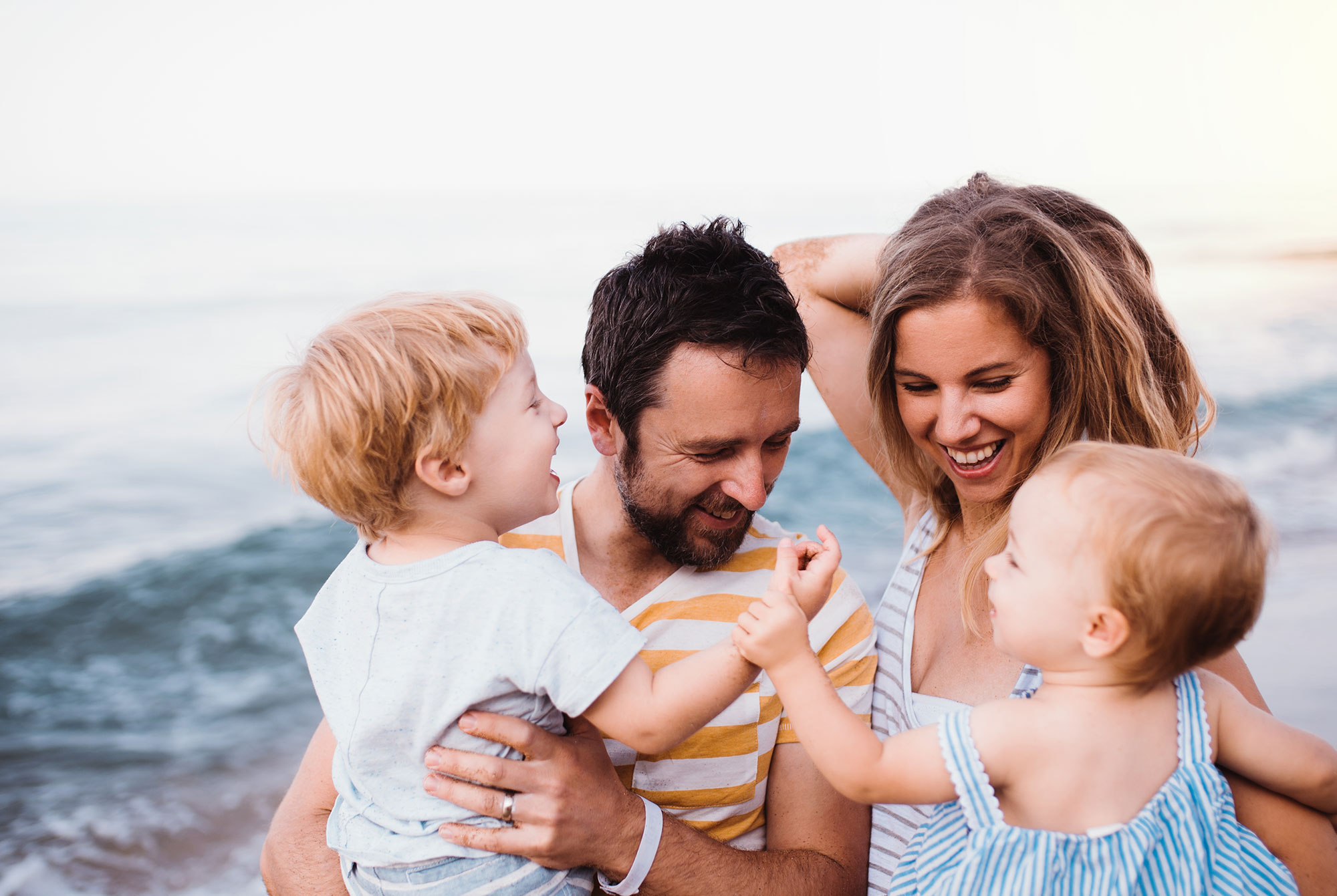 man and woman near the beach with their two children